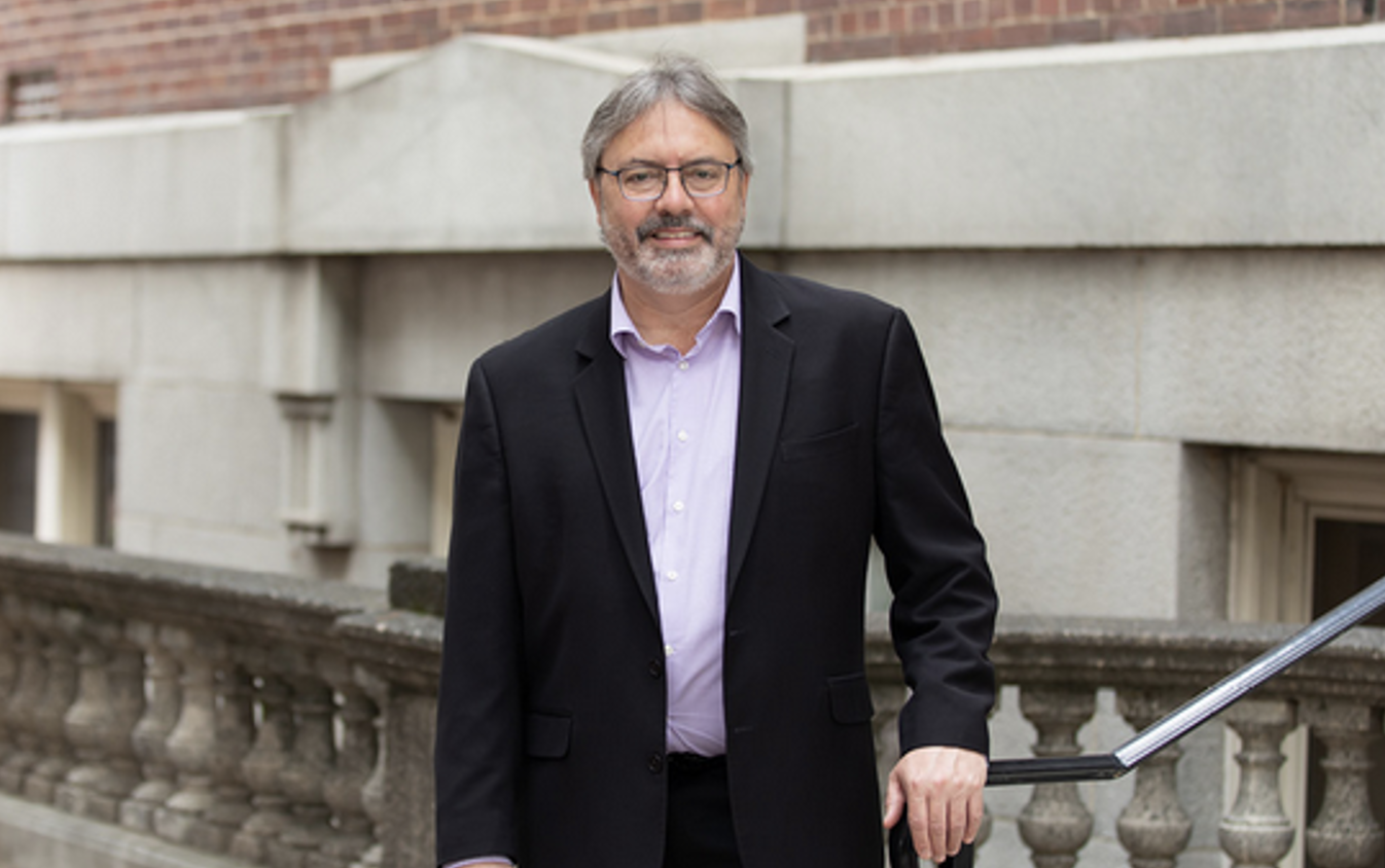 Richard Marconi stands outside a building wearing a suit jacket